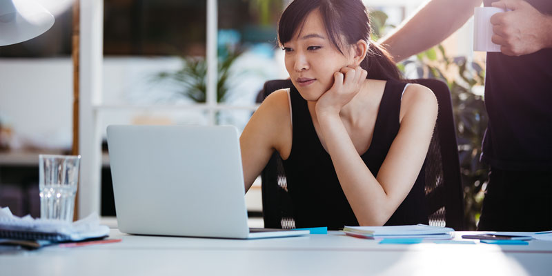 person sitting at table with laptop